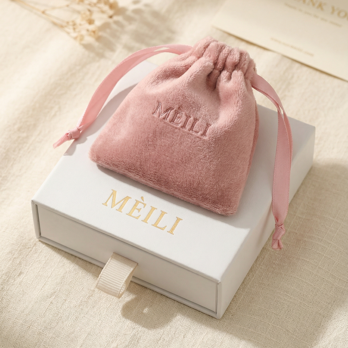 MÈILI jewellery packaging with a pink velvet pouch and white gift box