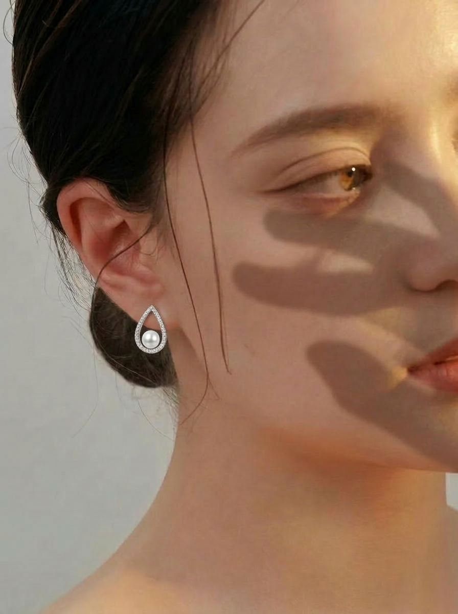 Portrait close-up of The Quiet Drop pearl zircon stud earring with a freshwater pearl worn on the ear