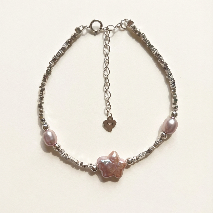 Bracelet with pink beads and chain on a light background
