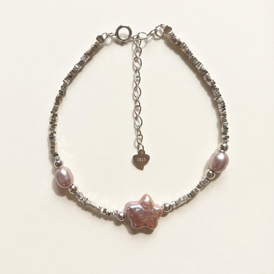 Bracelet with pink beads and chain on a light background