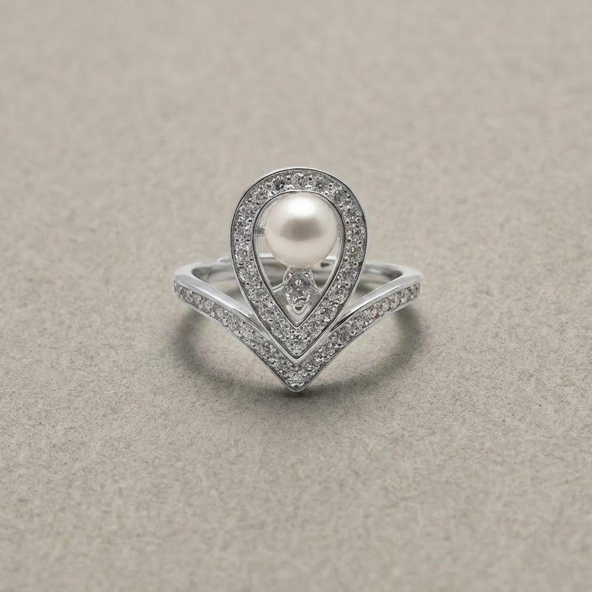 Silver ring with a pearl and diamond accents on a beige background