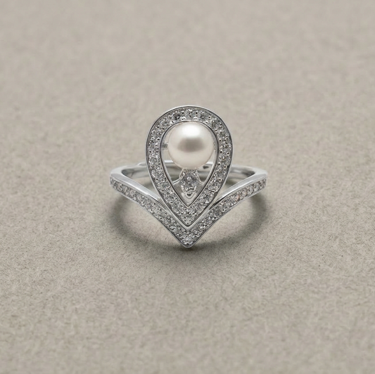 Silver ring with a pearl and diamond accents on a beige background