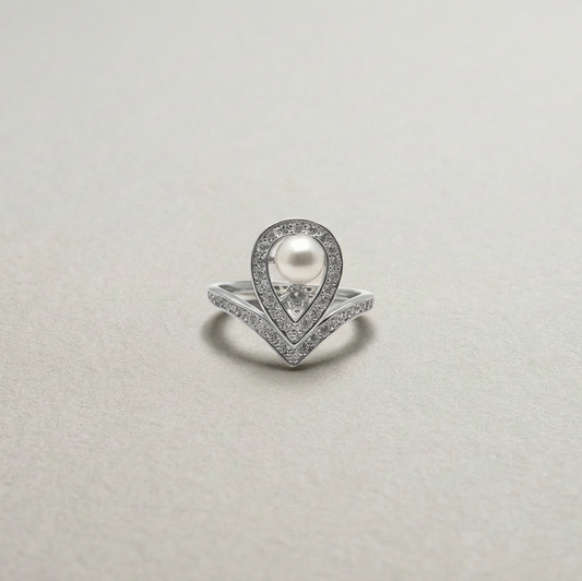 Silver ring with a pearl and diamonds on a light gray background