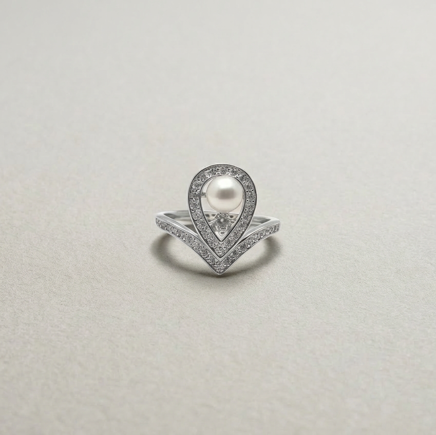 Silver ring with a pearl and diamonds on a light gray background