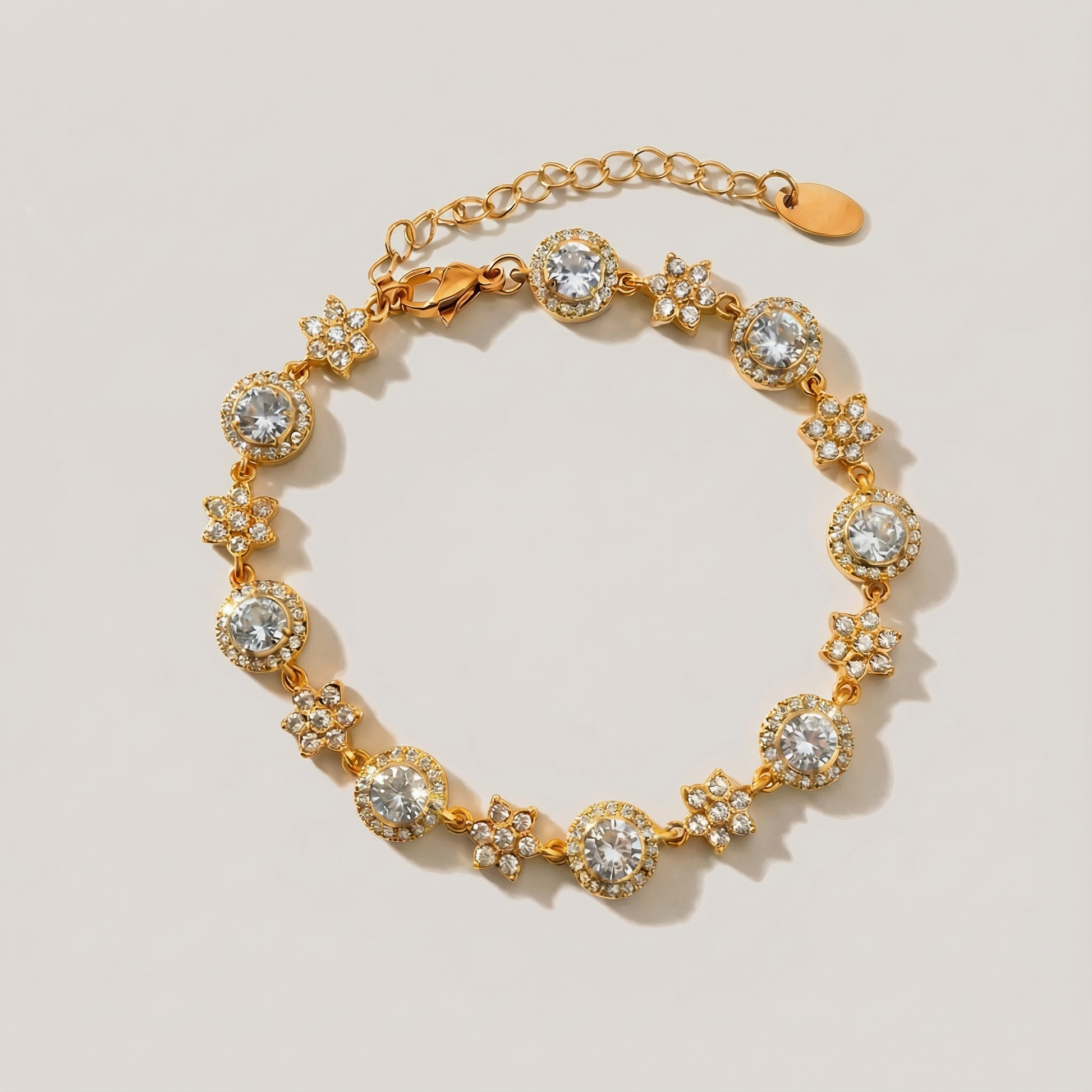 Gold bracelet with diamond-like stones on a light beige background
