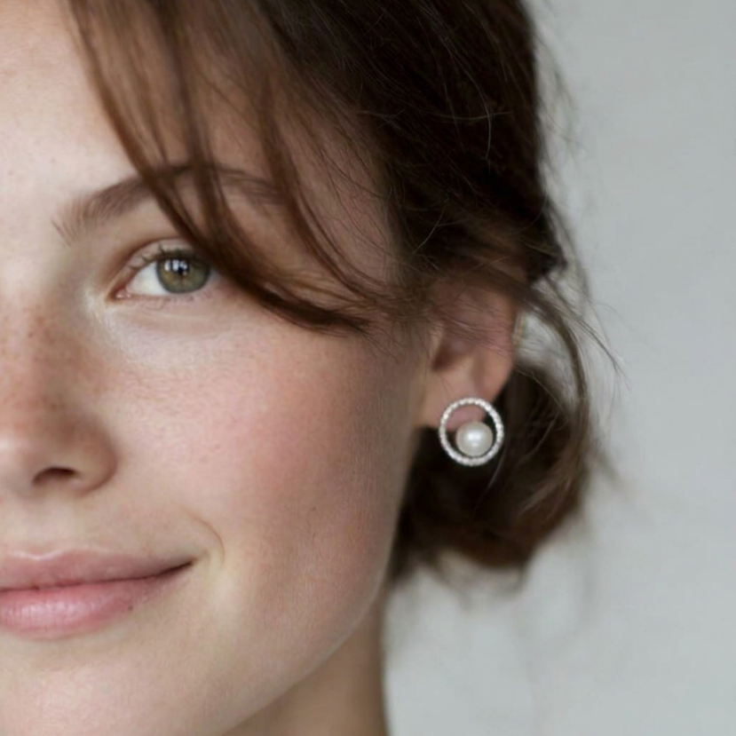 Portrait close-up of The Halo Pearl zircon-set stud earring with a freshwater pearl worn on the ear