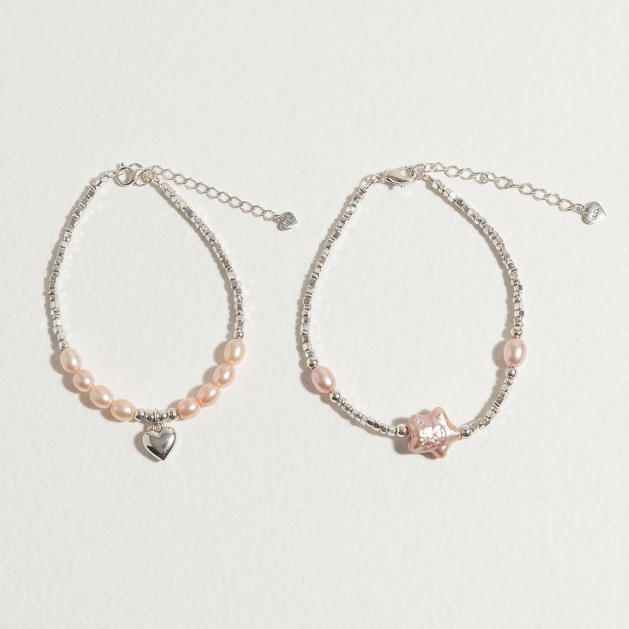 Full comparison view of two sterling silver bracelets, one with peach freshwater pearls and a heart charm and one with pink pearl details and a star-shaped centre, on a light beige background
