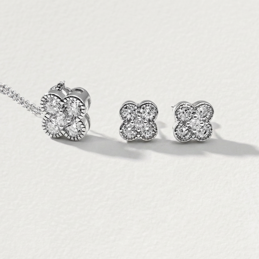 Clover Shine silver stud earrings with matching clover necklace on a light background