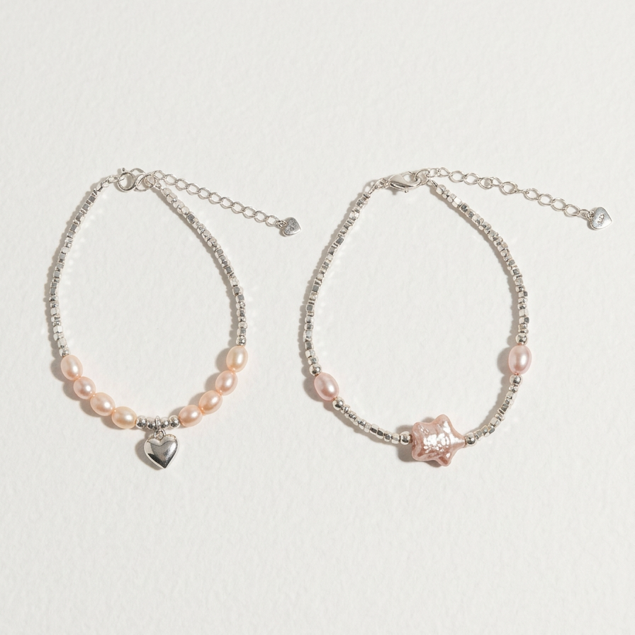 Two sterling silver bracelets shown together, including The Lavender Star bracelet and a matching heart charm bracelet