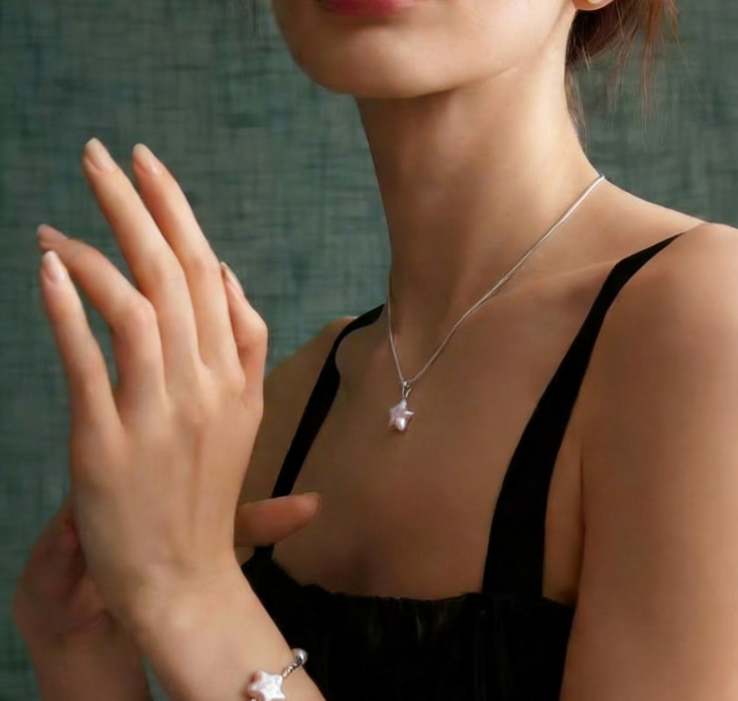 Model wearing a pink star-shaped baroque pearl necklace and matching bracelet in sterling silver
