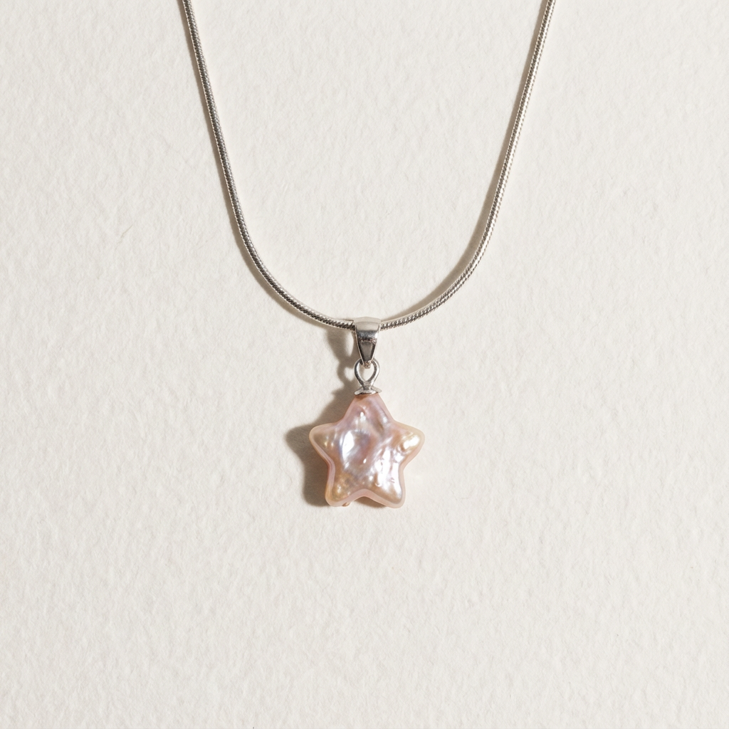 Pink star-shaped baroque pearl pendant necklace in sterling silver on a light beige background