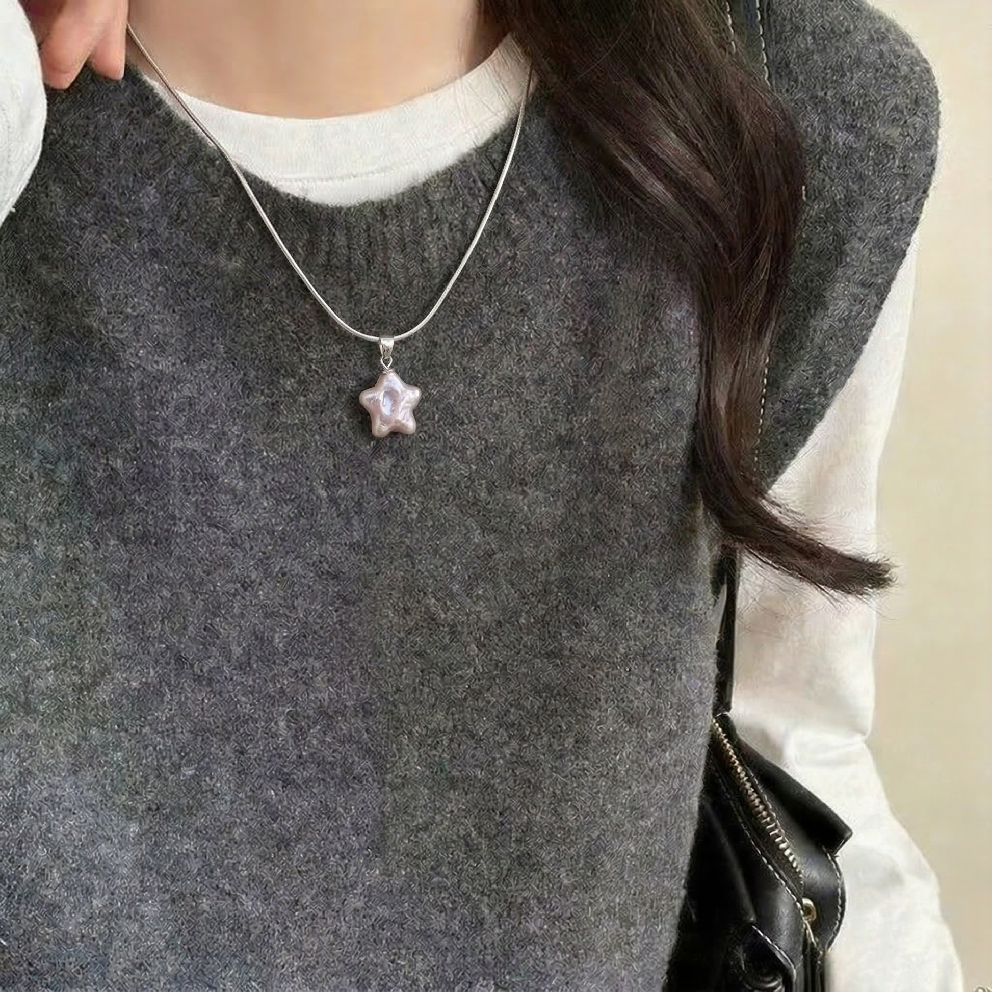 Model wearing a pink star-shaped baroque pearl pendant necklace in sterling silver with a casual outfit