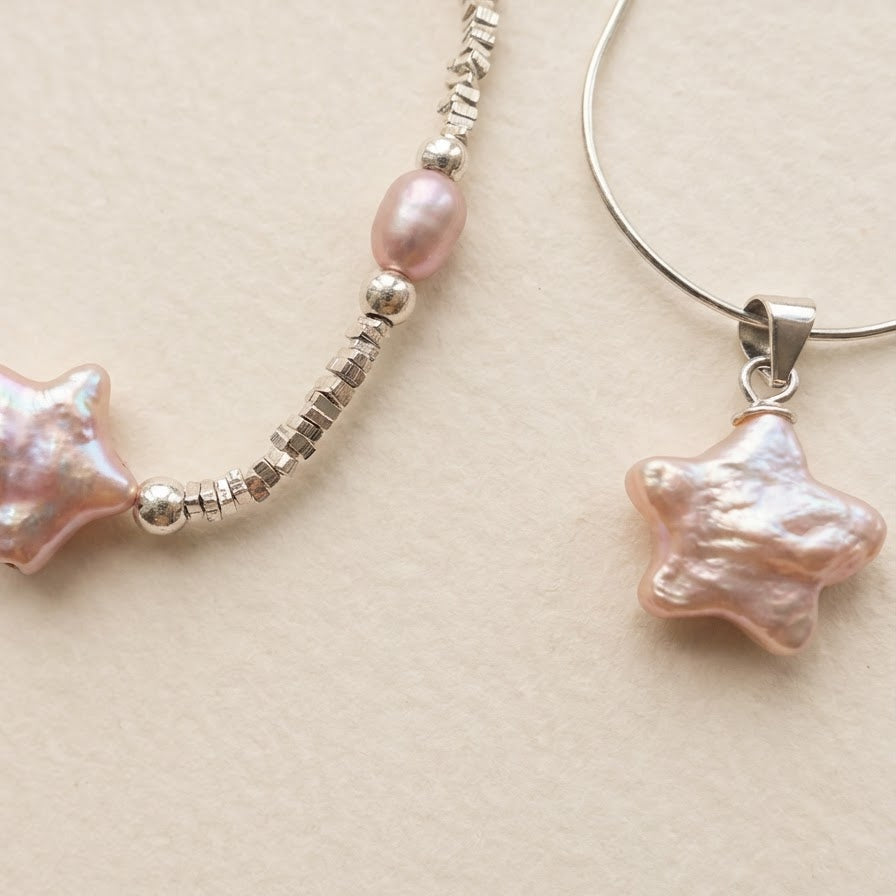 Close-up of pink star-shaped baroque pearl jewellery details showing sterling silver settings on a light beige background