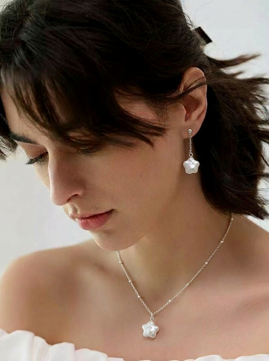 Model wearing the star baroque freshwater pearl necklace and drop earrings set in sterling silver