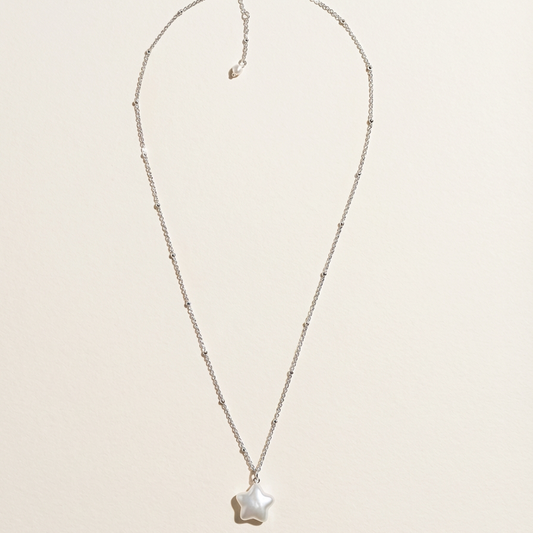 Star baroque freshwater pearl pendant necklace in sterling silver on a light beige background