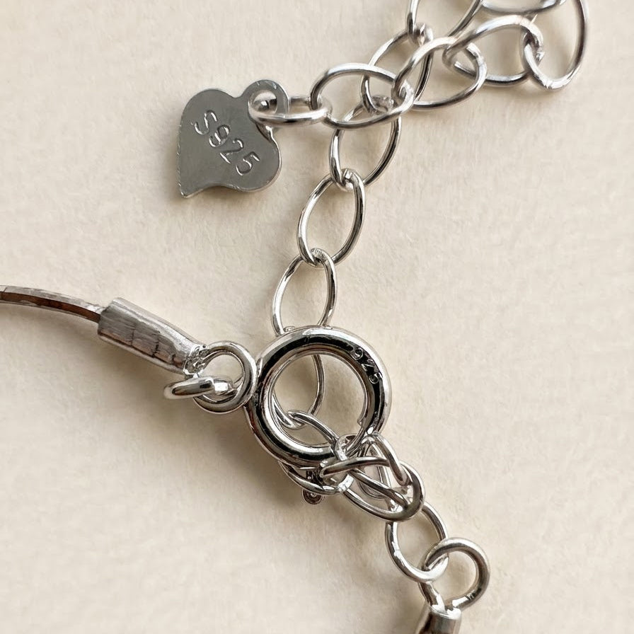 Close-up of the clasp, extension chain, and S925 tag on The Found Star baroque pearl necklace in sterling silver