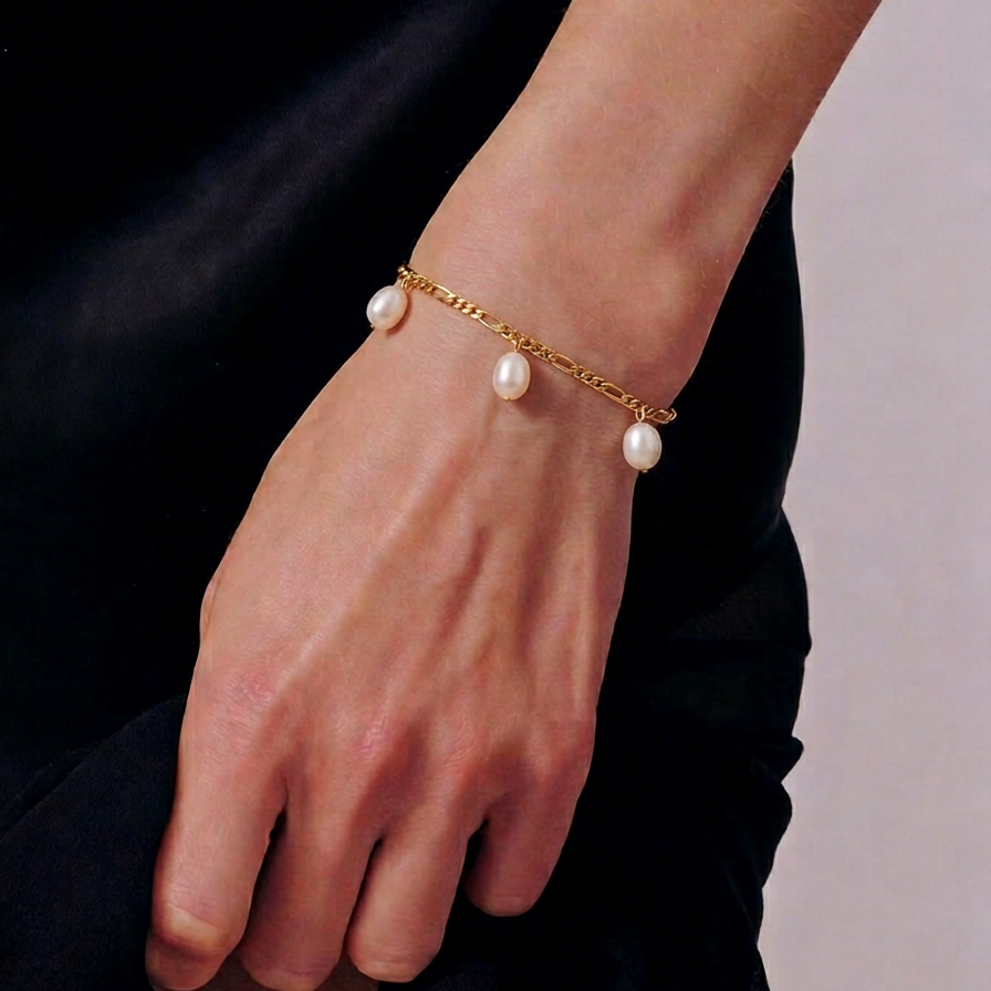The Halo Thread freshwater pearl bracelet in 18K gold-plated sterling silver, worn on the wrist with suspended freshwater pearls