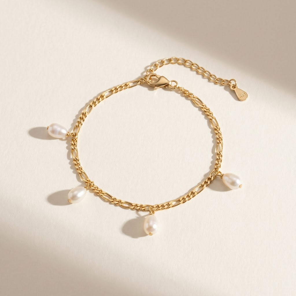 The Halo Thread freshwater pearl bracelet in 18K gold-plated sterling silver with suspended freshwater pearls, shown from above on a soft neutral background