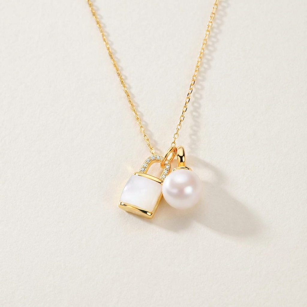 The Keeper’s Whisper necklace with a mother-of-pearl lock pendant and freshwater pearl shown in full view on a light background