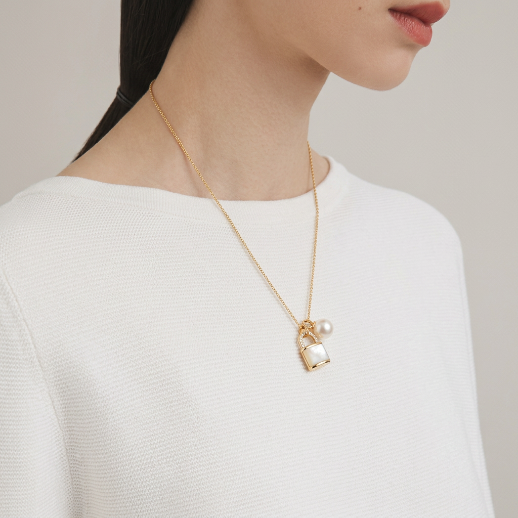 The Keeper’s Whisper necklace worn on the neck from a side view, featuring a mother-of-pearl lock pendant and freshwater pearl