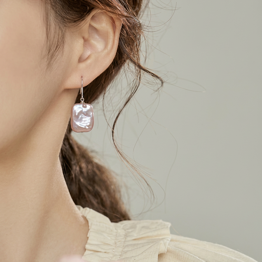 The Lavender Geometric baroque pearl drop earring worn on the ear in close-up