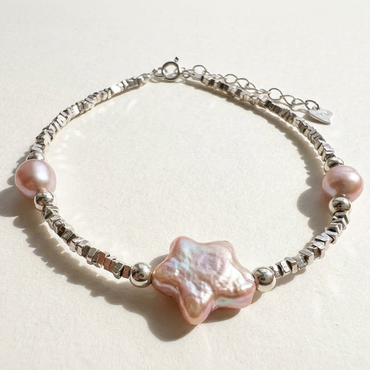 The Lavender Star baroque pearl and sterling silver bracelet with a star charm on a light background