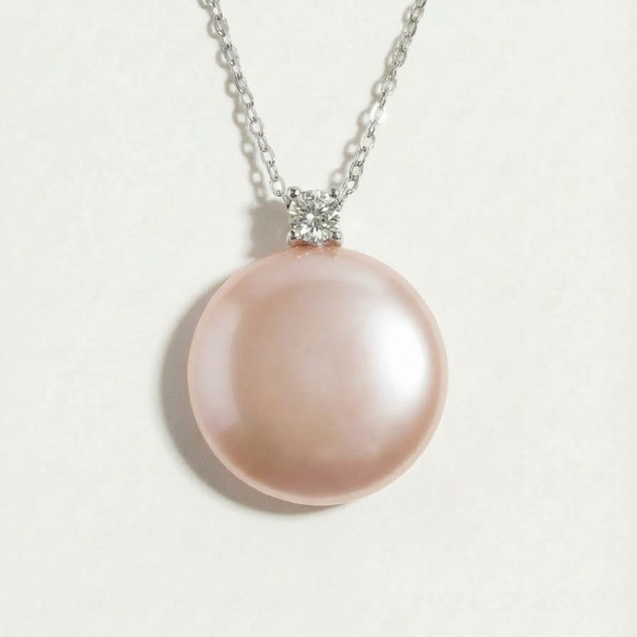 Extreme close-up of The Moondrop button pearl pendant necklace showing the round baroque freshwater pearl and sterling silver setting