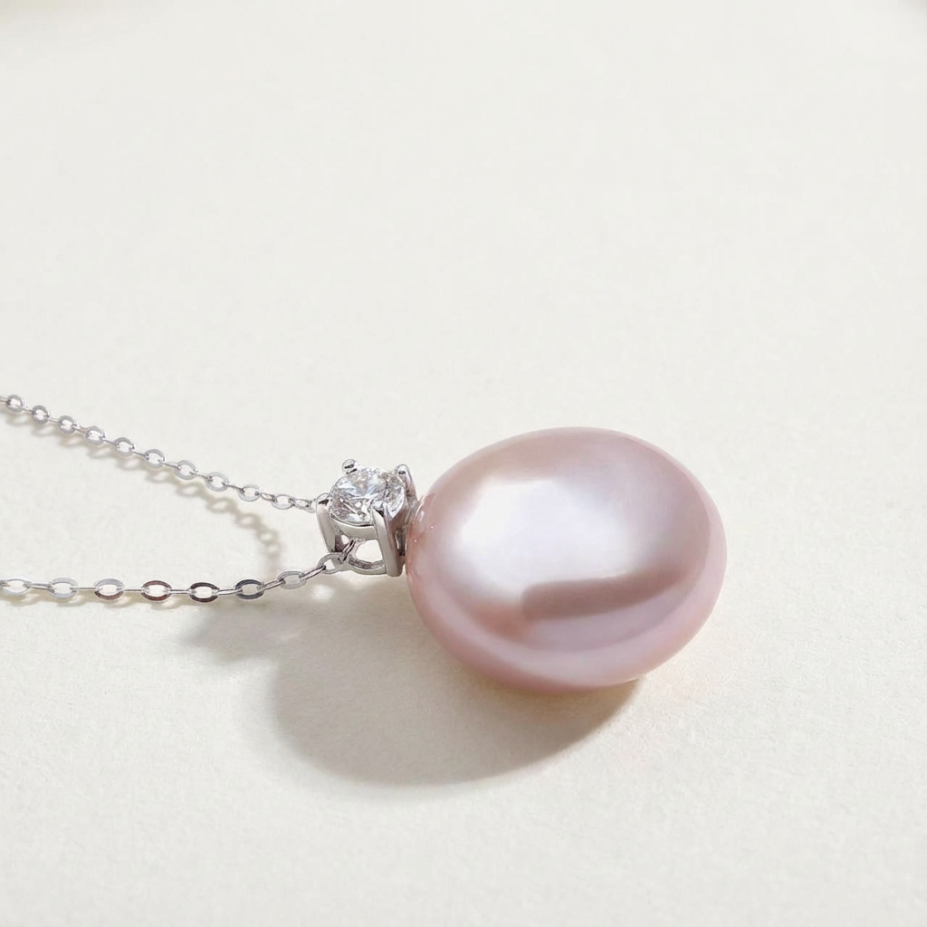 Side detail of The Moondrop button pearl pendant necklace showing the baroque freshwater pearl and sterling silver setting