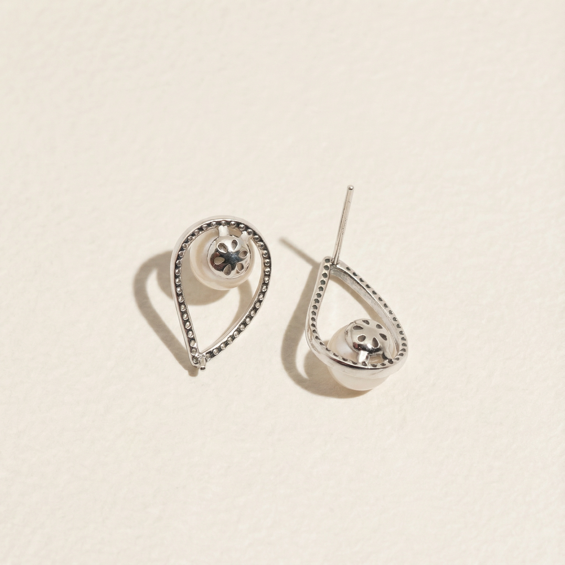 Back detail of The Quiet Drop pearl zircon stud earrings showing the post, underside of the pearl setting, and teardrop sterling silver frame