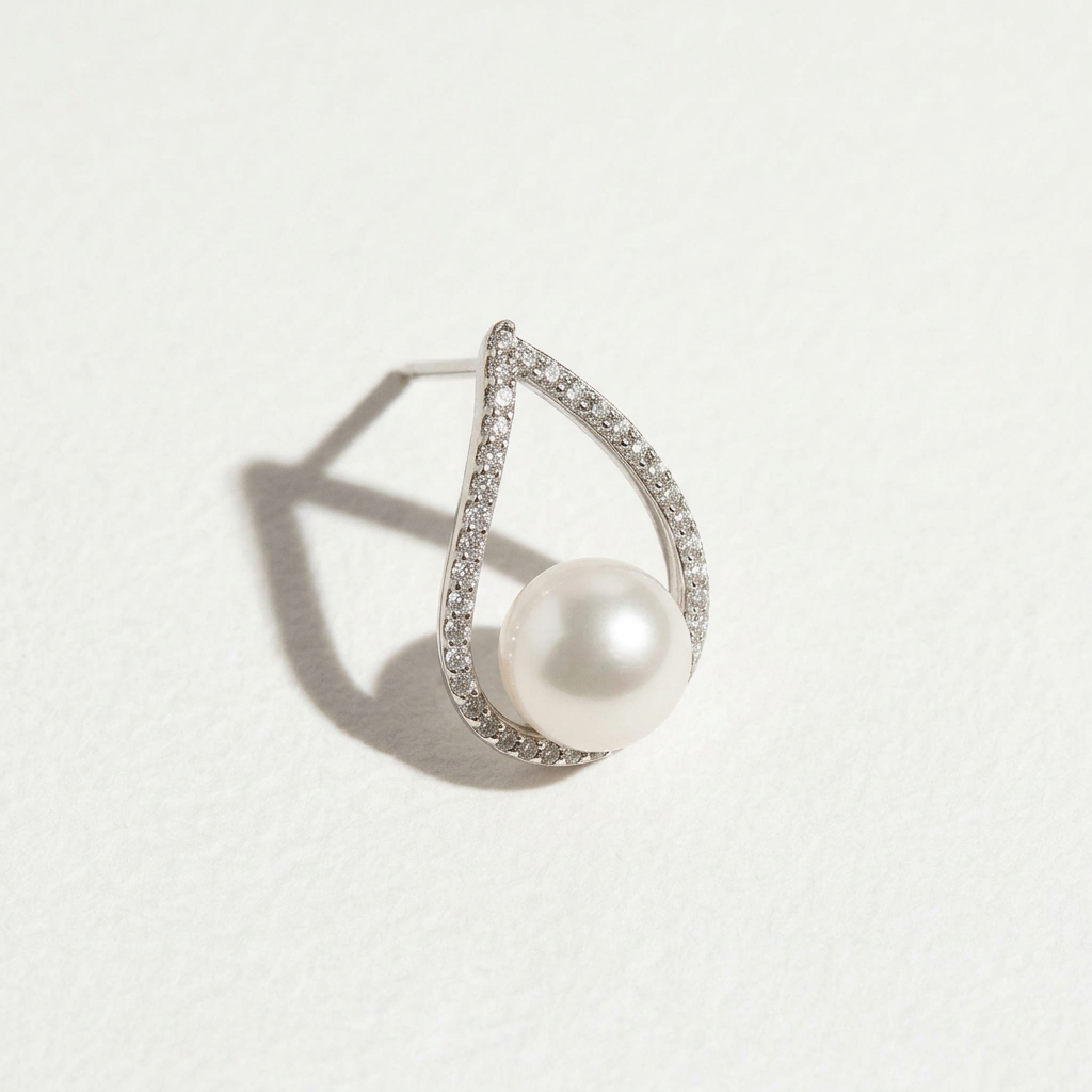 Single The Quiet Drop pearl zircon stud earring with a freshwater pearl in a teardrop sterling silver setting on a light background