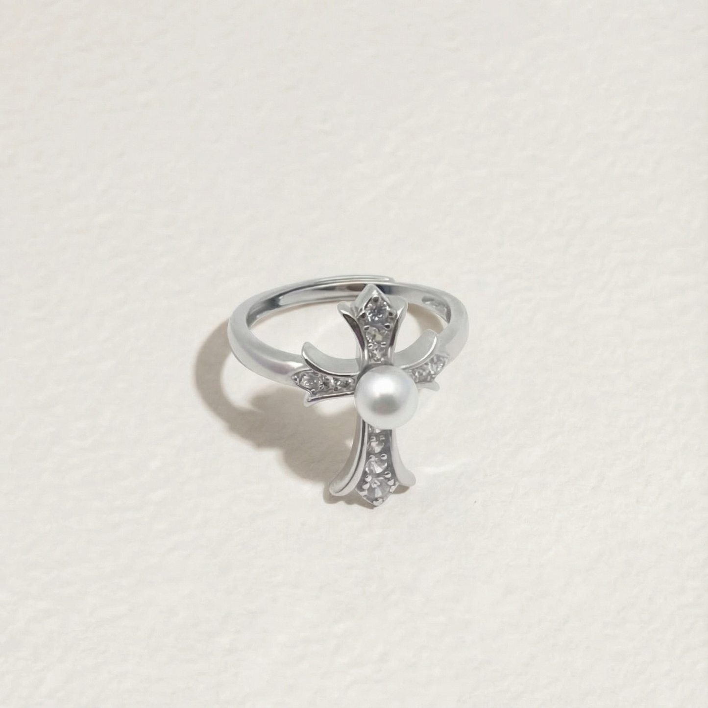 The Sacred Glow pearl cross ring with a freshwater pearl and zirconia shown in full view on a light background
