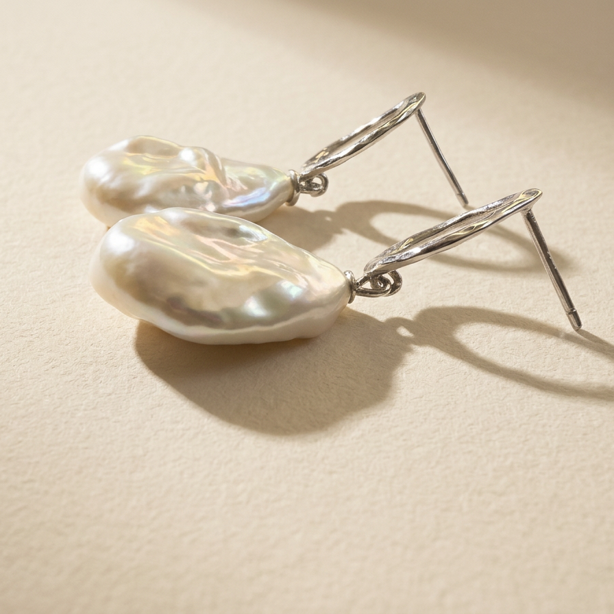 Side view of The Silver Drift baroque pearl drop earrings in sterling silver with natural baroque freshwater pearls
