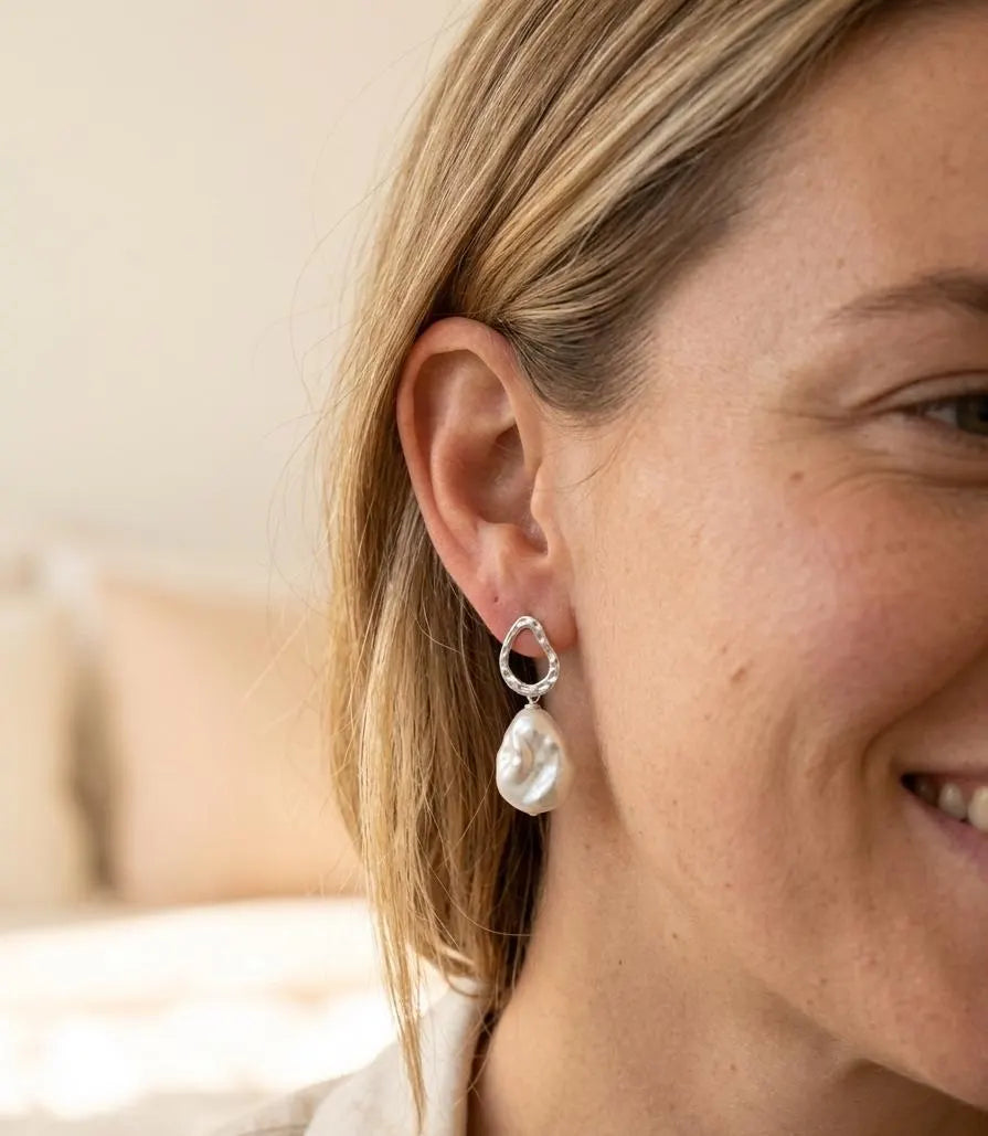 The Silver Drift baroque pearl drop earrings worn on the ear