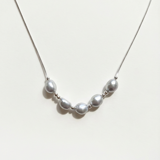 The Silver Mist grey baroque pearl necklace with sterling silver beads on a light background
