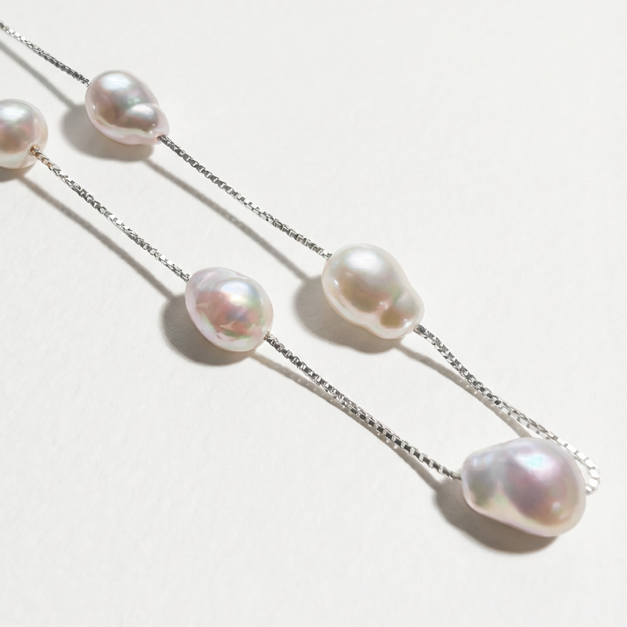 Close-up of The Stardust Path necklace showing irregular natural pearls spaced along a sterling silver chain