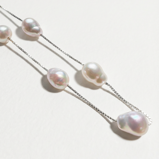 Close-up of The Stardust Path necklace showing irregular natural pearls spaced along a sterling silver chain