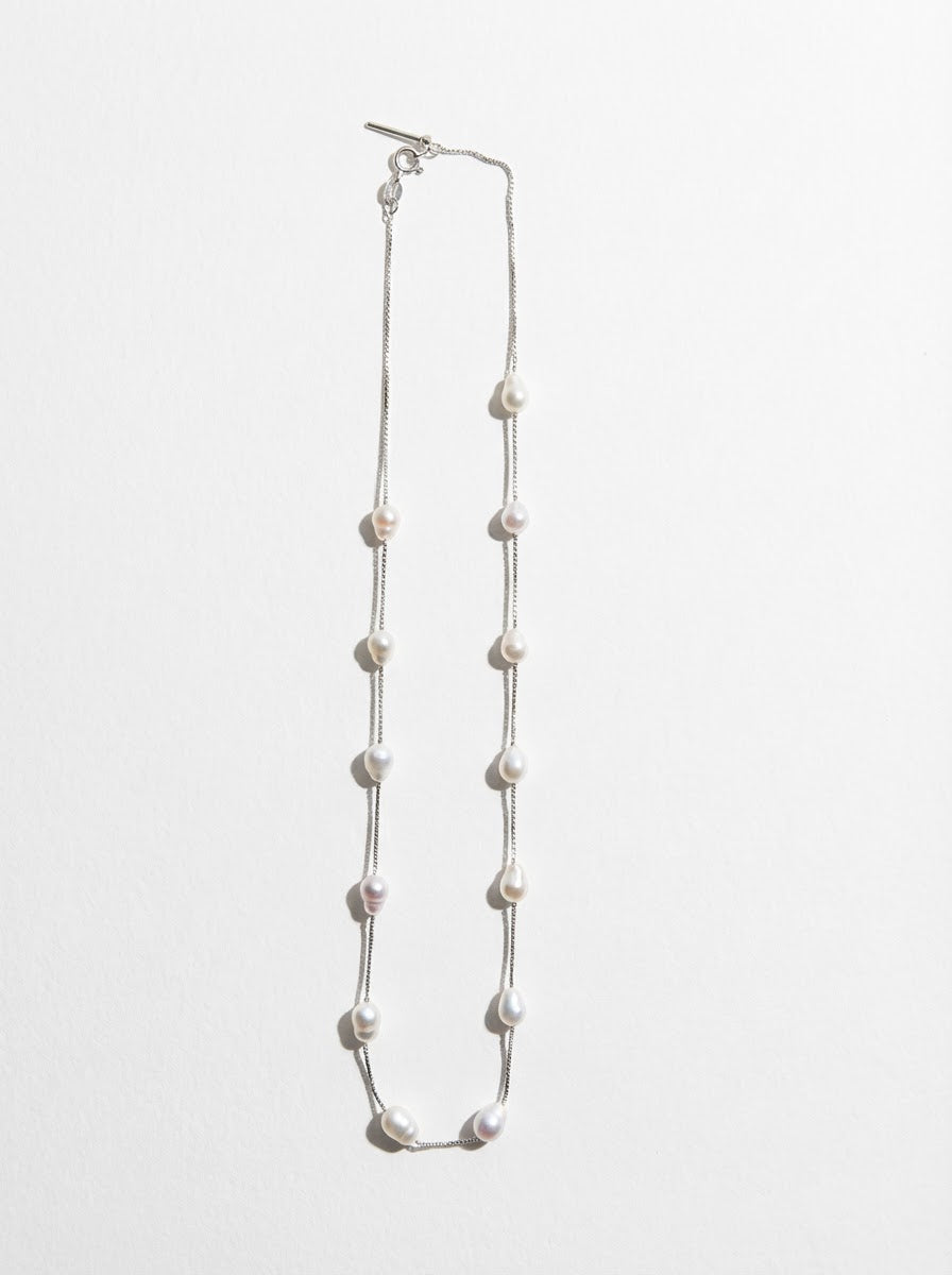 The Stardust Path necklace shown in vertical full view with irregular natural pearls spaced along a sterling silver chain