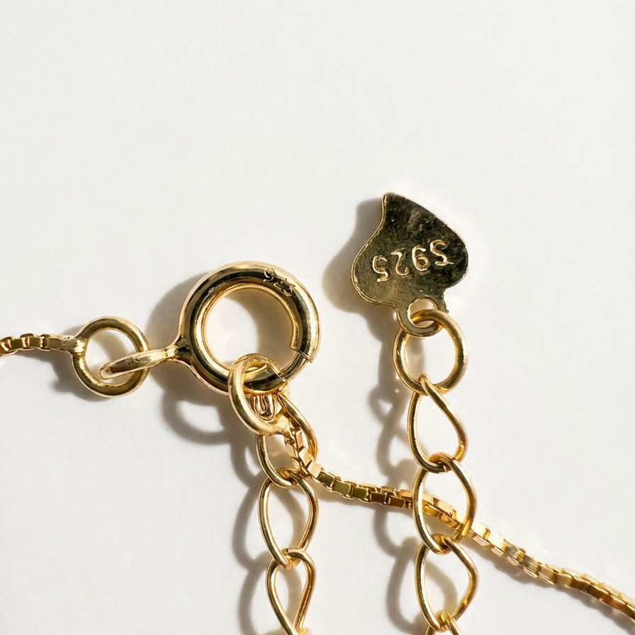 The Steady Pearl necklace clasp in gold-plated sterling silver with extender chain and S925 tag on a light grey background