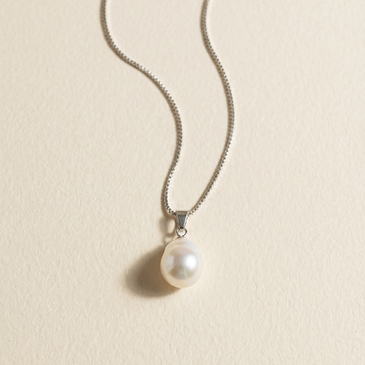 The Steady Pearl necklace in sterling silver with a single baroque freshwater pearl on a warm beige background