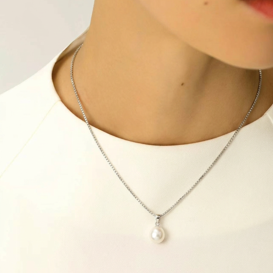 The Steady Pearl necklace worn at the collarbone in sterling silver with a single baroque freshwater pearl