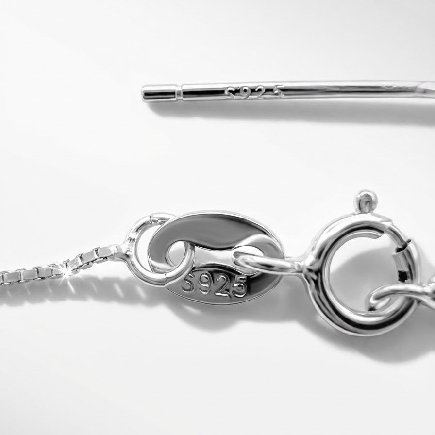 The Sunlit Key necklace clasp in sterling silver with S925 tag on a light grey background