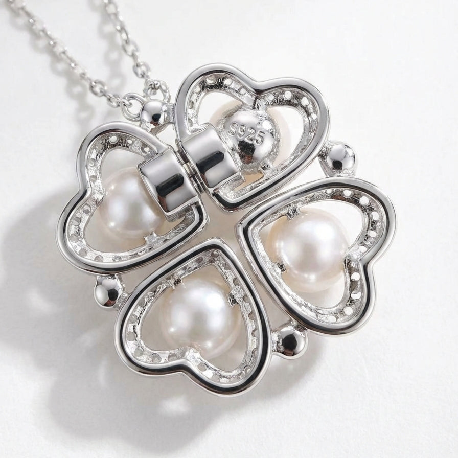 The Turning Heart necklace in sterling silver shown from the back with four freshwater pearls in a two-way heart and clover pendant on a light grey background