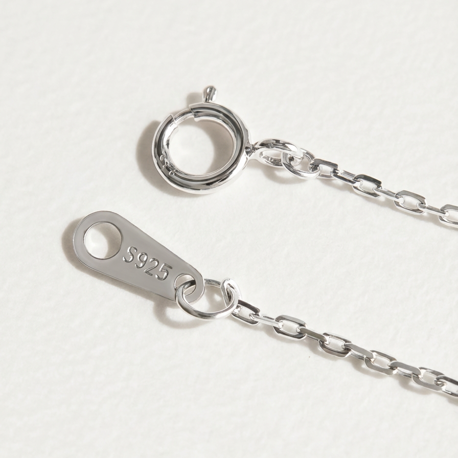 The Turning Heart necklace clasp in sterling silver with S925 tag and extender chain on a light grey background