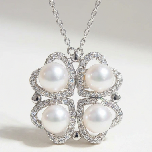 The Turning Heart necklace in sterling silver with four freshwater pearls framed by pavé zirconia on a light grey background
